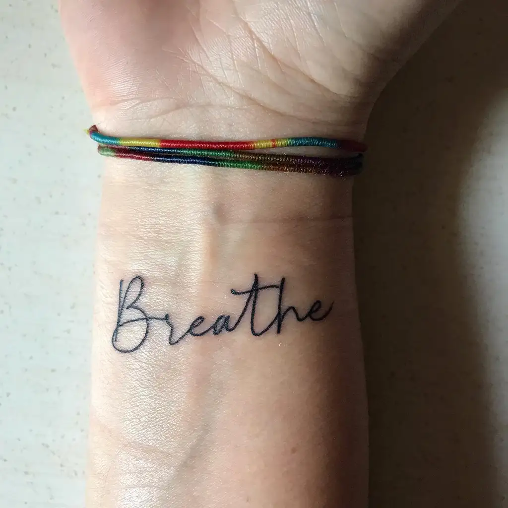 Wrist Tattoo with “Breathe” Script