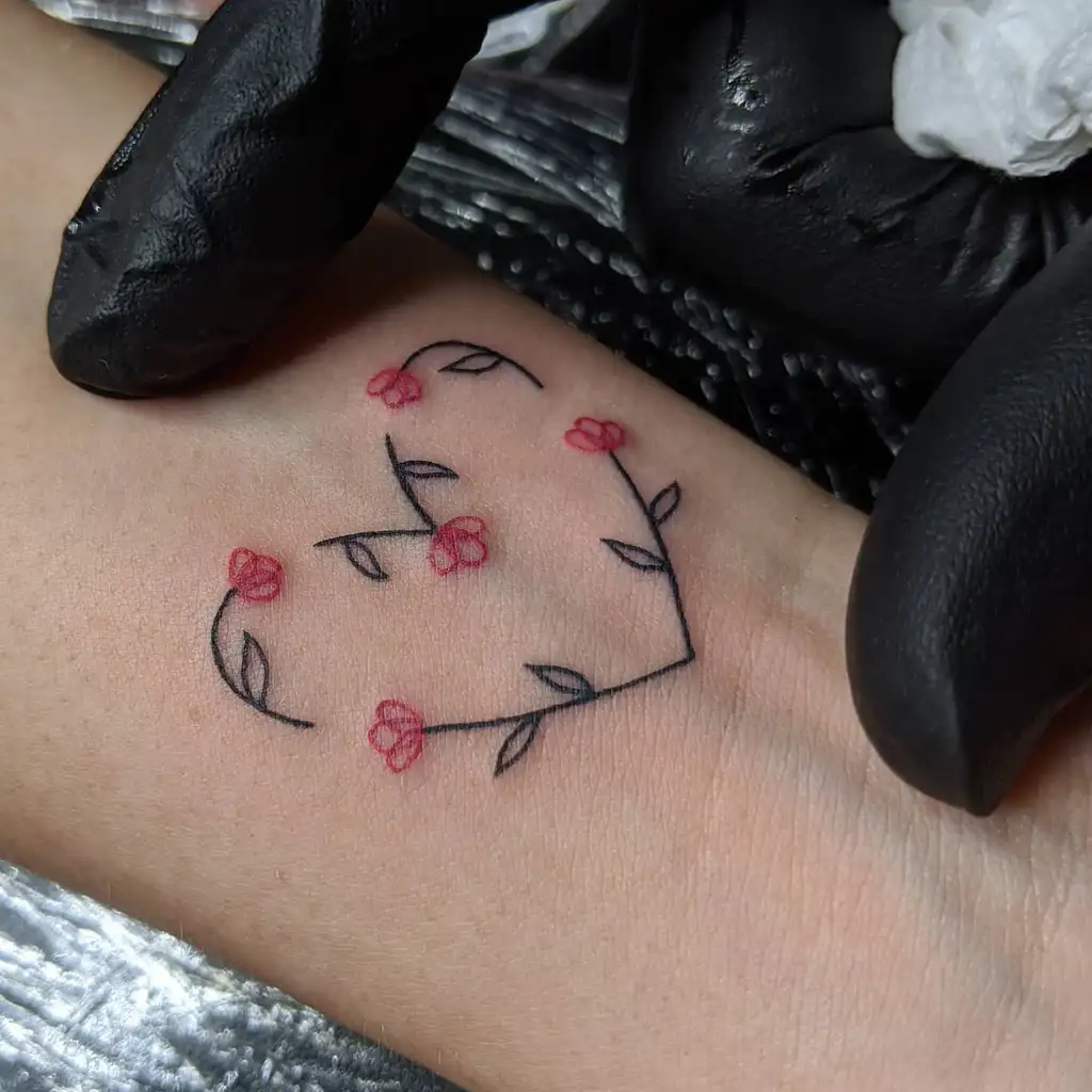 Wrist Tattoo of Heart-Shaped Flower Vine
